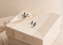 Cream gift box with MJ monogram and ribbon